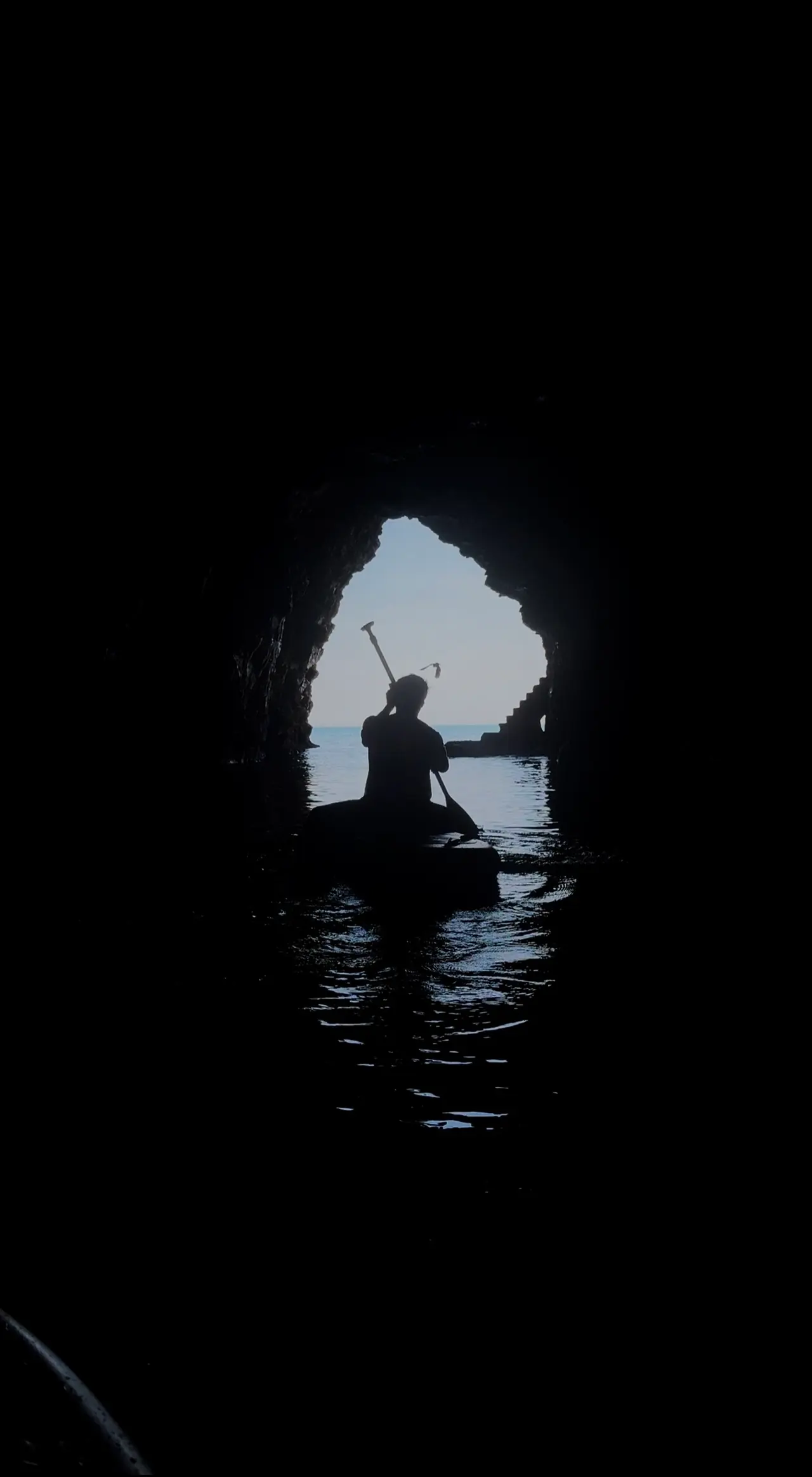 A paddler at the cave mouth, seen from inside